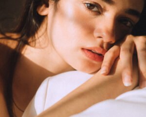 model resting on a white covered sheet, looking straight into the camera, skin bare defining how the nerves fibre tuned to 3 centimetres a second 