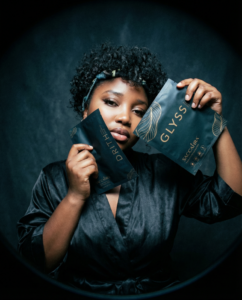 stylized portrait of a person holding Saccahra's face sheet masks close to their face against a dark background