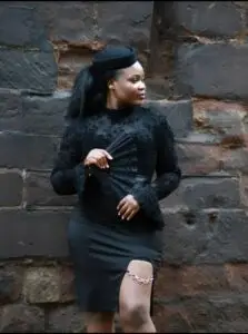 founder of Saccahra brand poised against a brick-wall. My Story. The Nurse in Me. The Heart Behind Saccahra