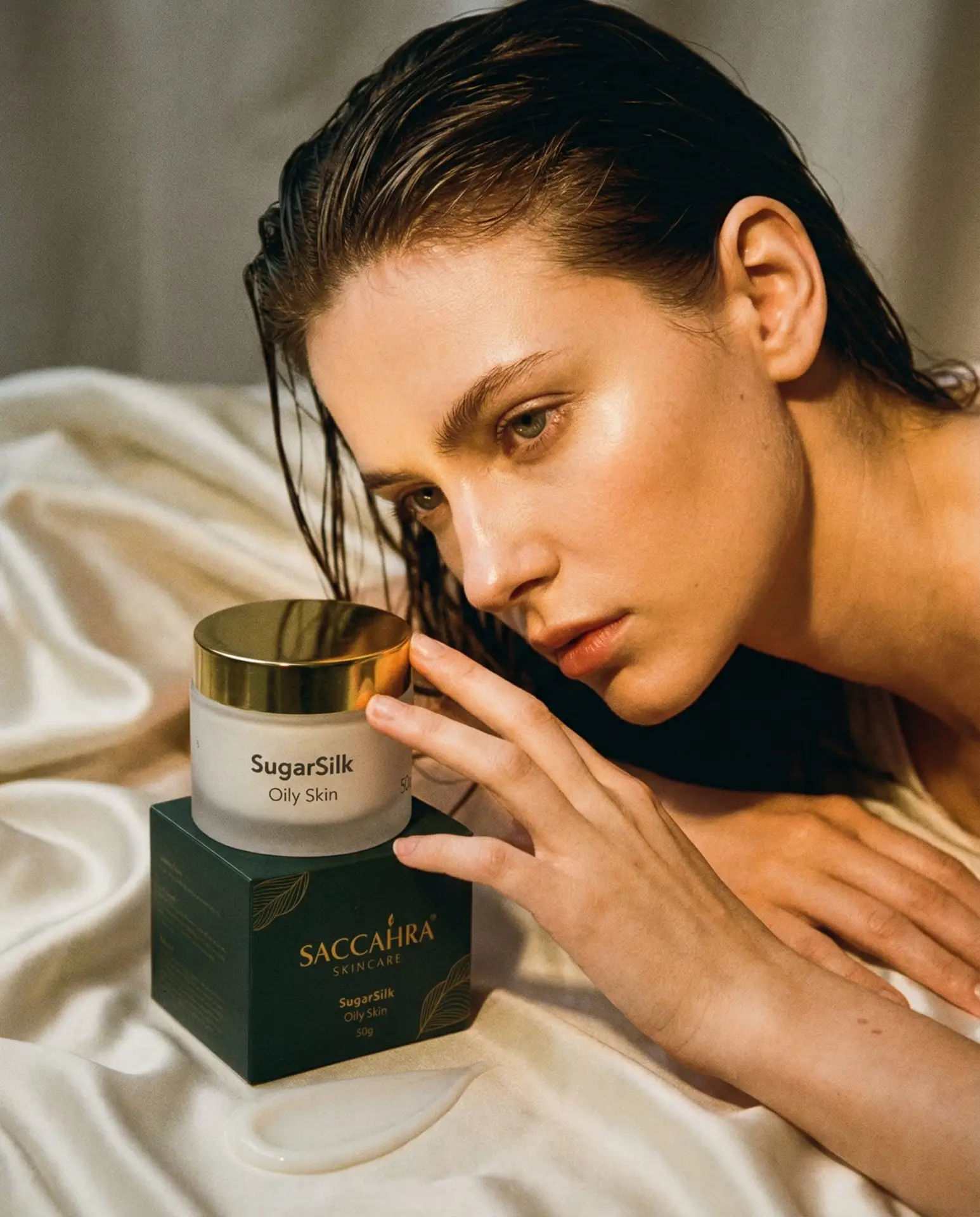 A close intimate shot of a person leaning toward a jar of SugarSilk for Oily skin, capturing moisture, softness and the quiet power of nighttime skincare