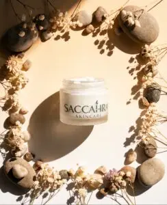Flat lay of Saccahra's product centered inside a rustic, circular wreath made of dried leaves, seed pods, and twigs