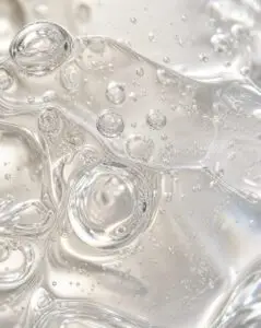 Ahigh-end macro texture shot of a clear, fluid skincare thick gel illustrating how biomimetic lipids breathe with your skin.